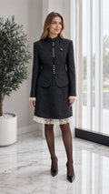 Front view of model wearing black tweed stand collar blazer and matching lace hem skirt