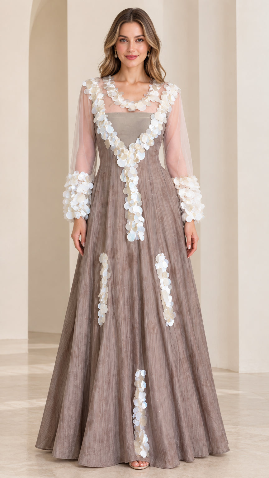 Front full-length view of taupe A-line evening gown with sheer mesh sleeves and white 3D petal appliqué trims