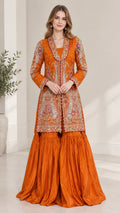 Front view of woman wearing Rust Orange embroidered jacket and flared sharara pants set