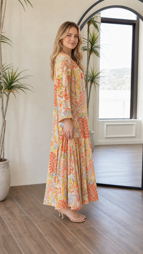 Side profile view of woman wearing bohemian yellow multi tiered maxi dress