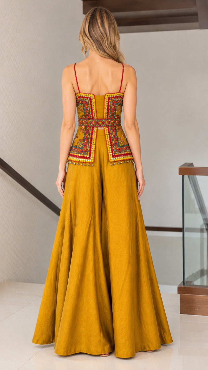 Back view of mustard yellow embroidered camisole top and sweeping wide-leg trousers